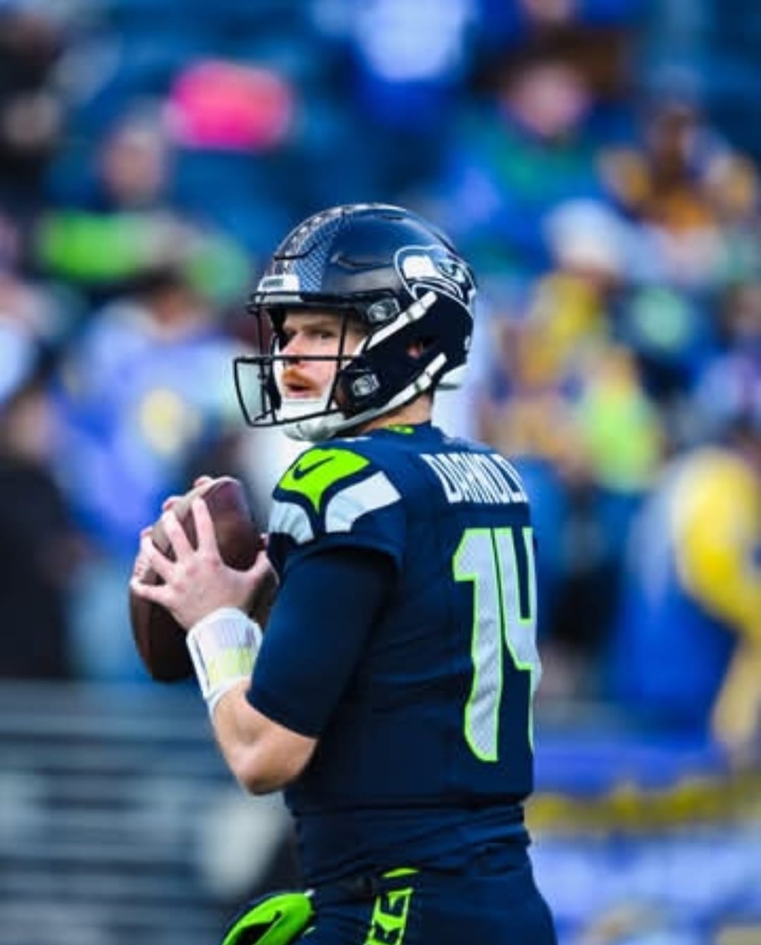 Quarterback Sam Darnold do Seattle Seahawks com a bola observando.